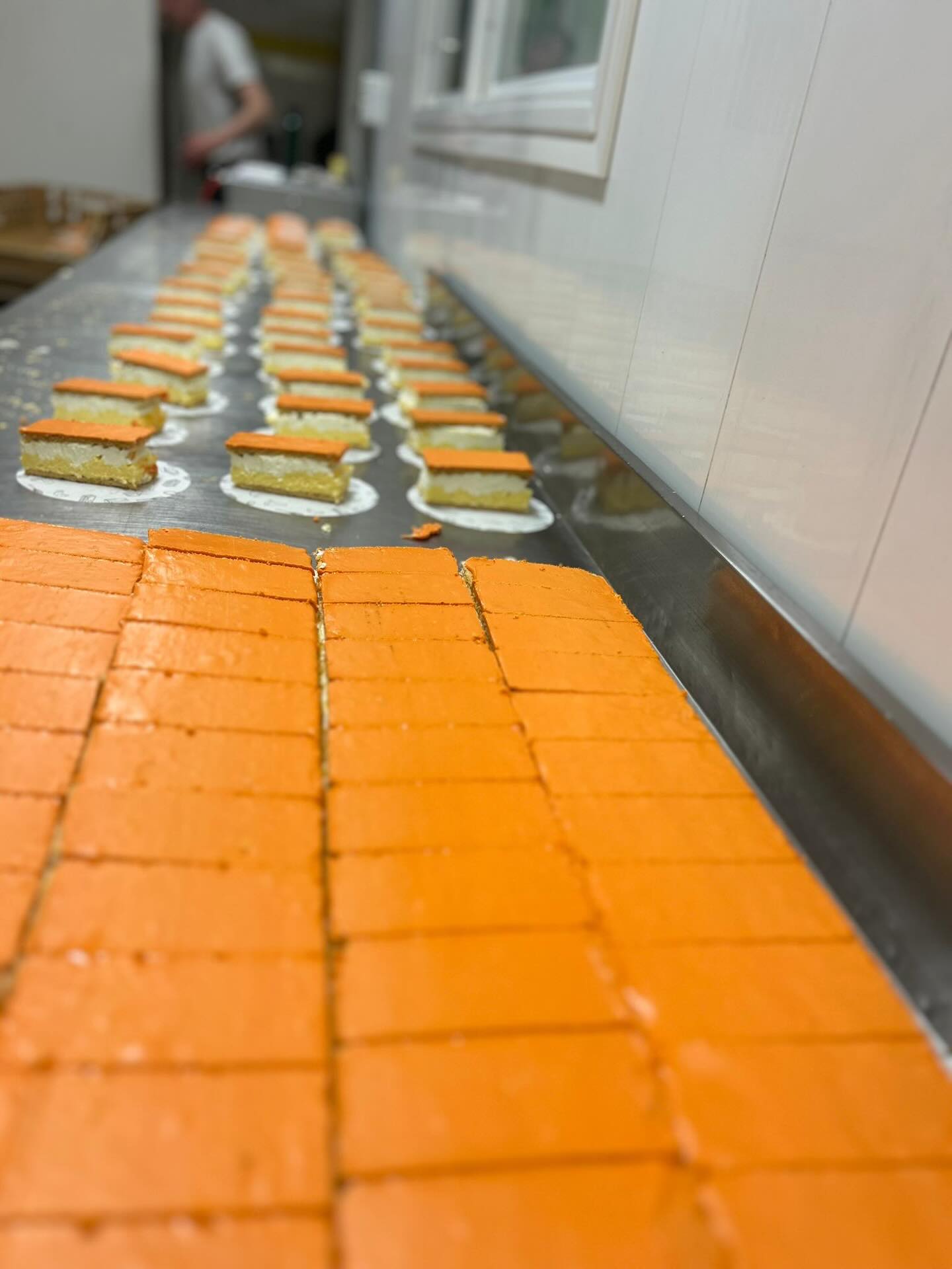 Oranje tompouces op een rij in de bakkerij van Borger